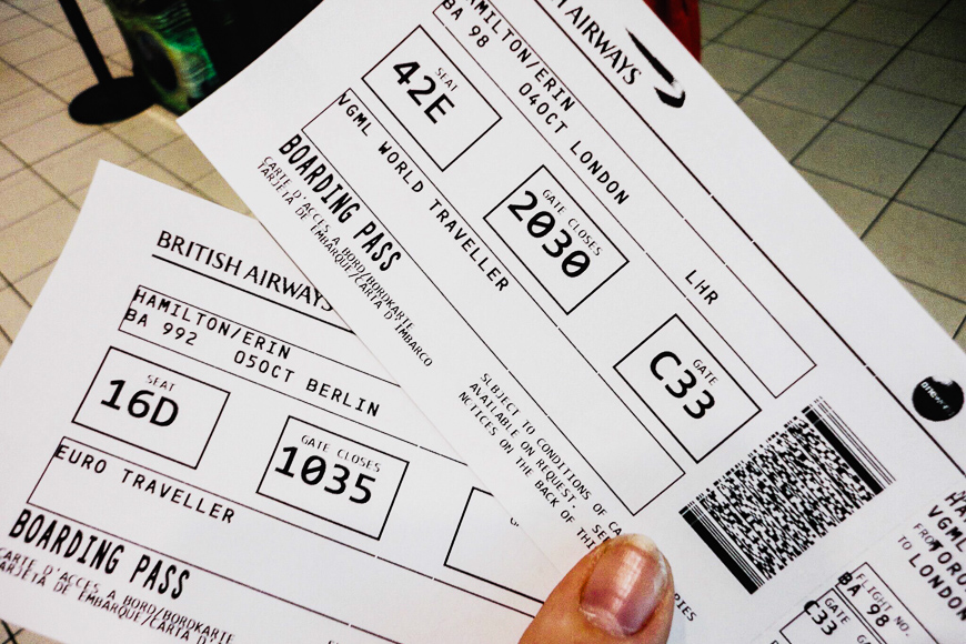 person holds two paper boarding passes