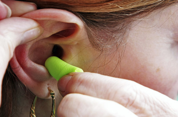 Earplugs or noise-canceling headphones