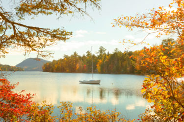 Long Pond seen through trees with autumn foliage in Acadia National Park in Maine, United States
