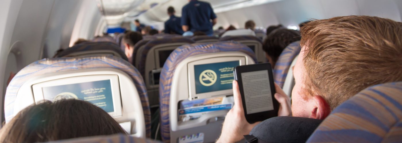 man reading kindle on plane.