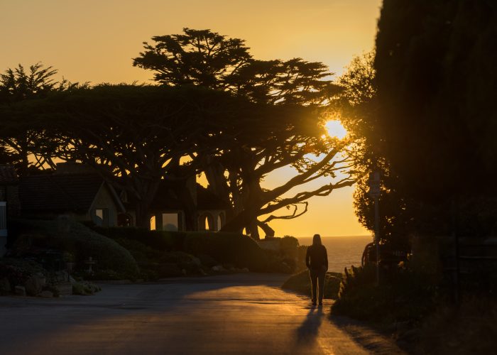 Woman walking at sunset in Carmel-by-the-Sea