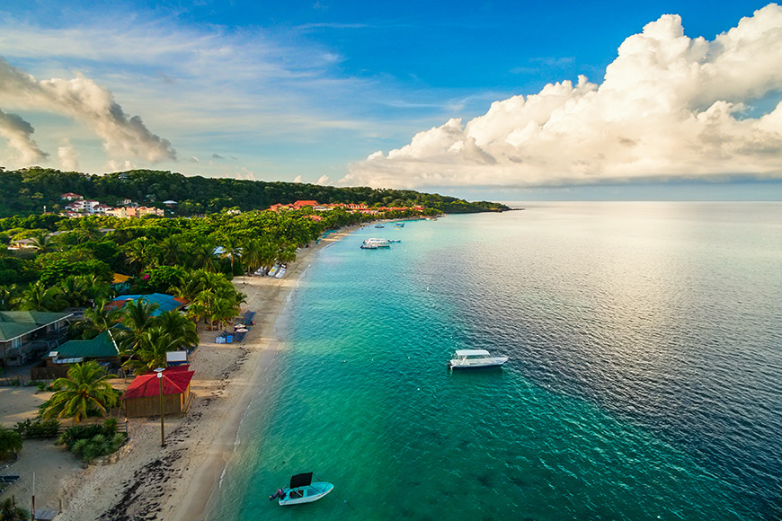 An aerial view of a tropical beach in roatán honduras early the morning.