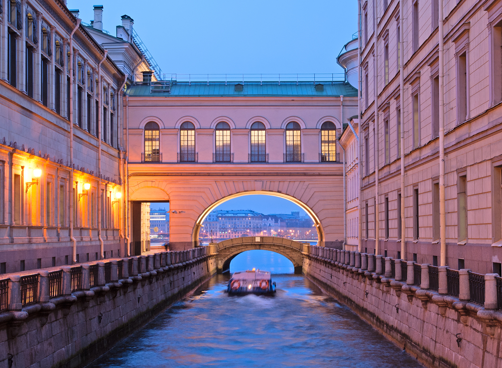 boat going through archway on canal in st. petersburg russia.