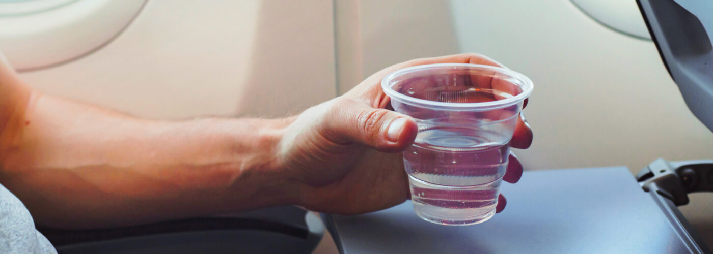 Passenger drinking water in airplane during flight.