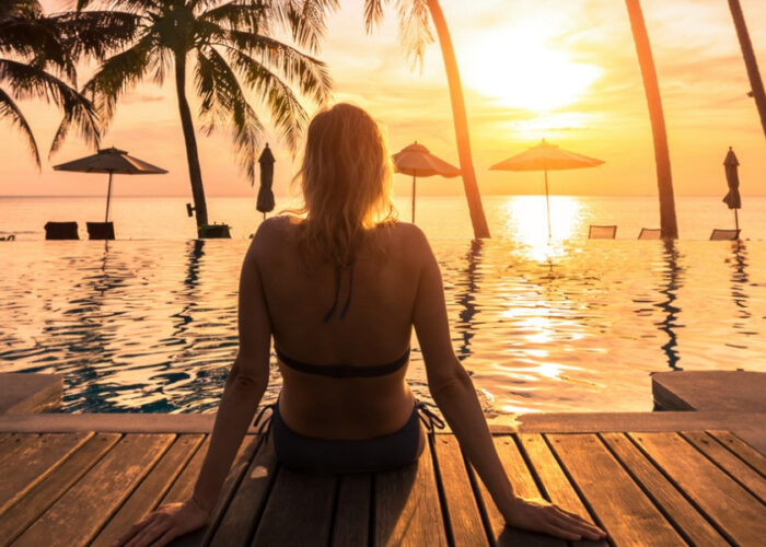 woman sitting at sunset at tropical resort.