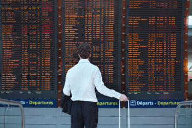 Man looking at departures board at airport