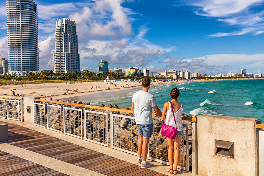 Miami beach tourists couple walking in South Beach, Miami, Florida.