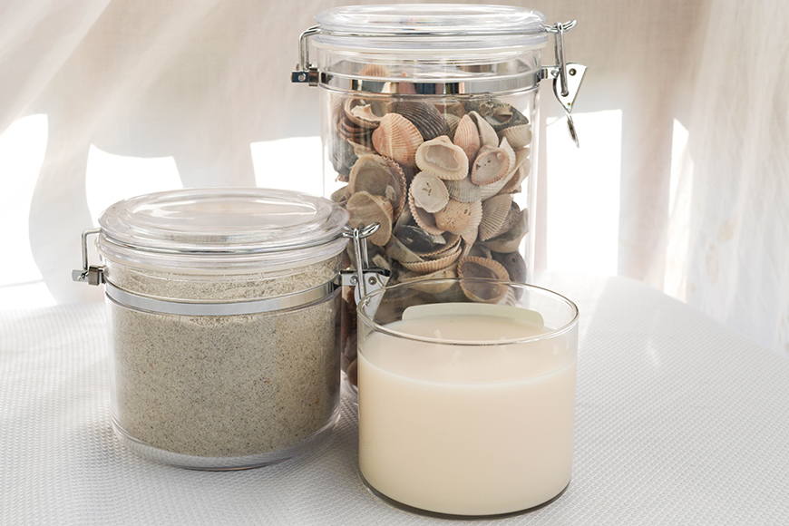 candle and glass jars of sand and shells.