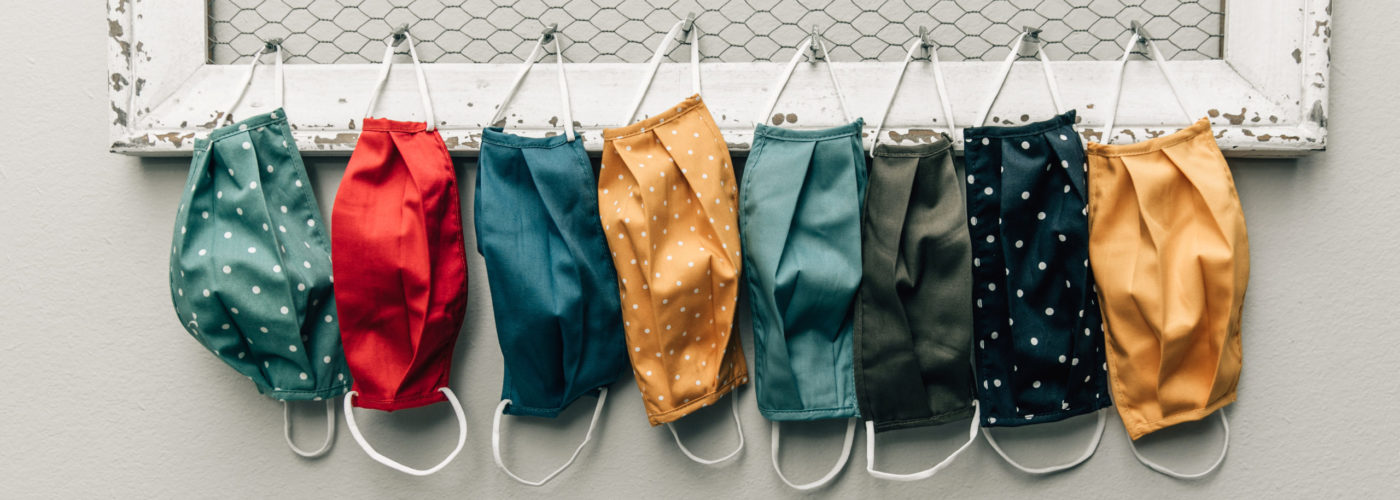Row of cloth face masks hanging on hooks
