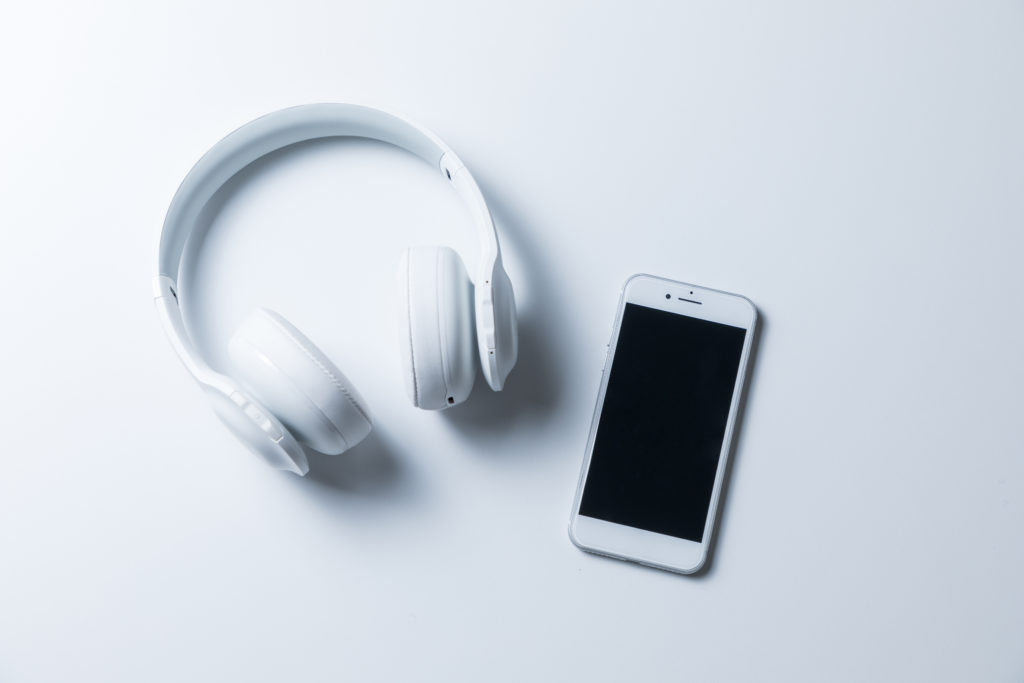 Wireless headphones and smartphone on a white background