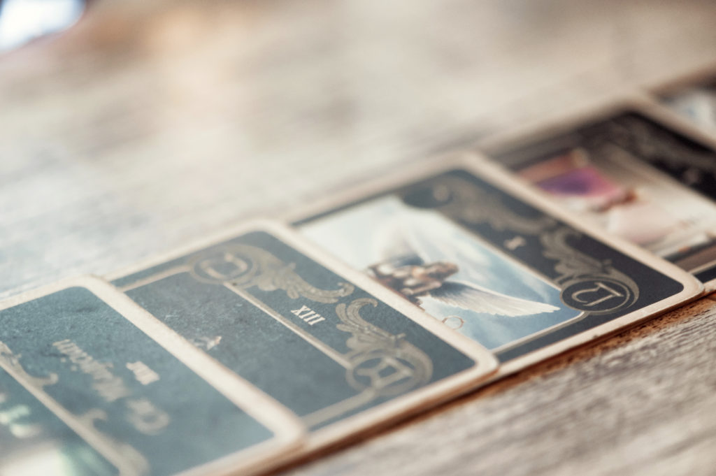 A line of tarot cards spread out on a wooden table