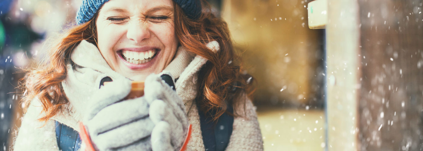 Women wearing winter gear and holding a hot drink