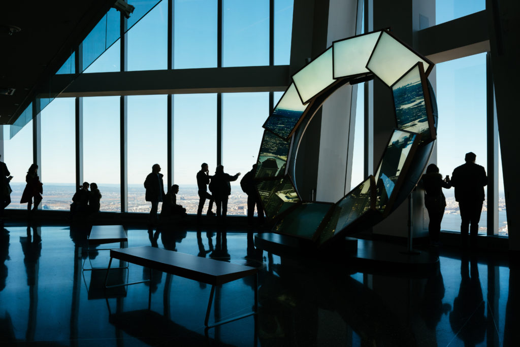 People looking out the windows of the One World Observatory in New York City, United States