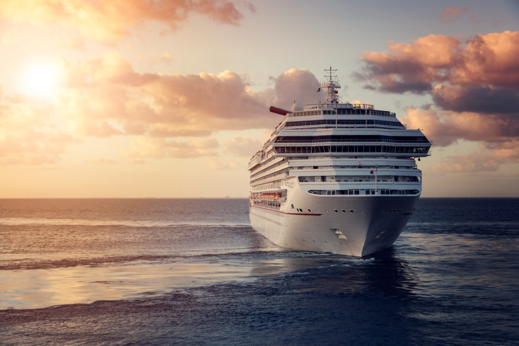 Cruise ship in ocean at sunset