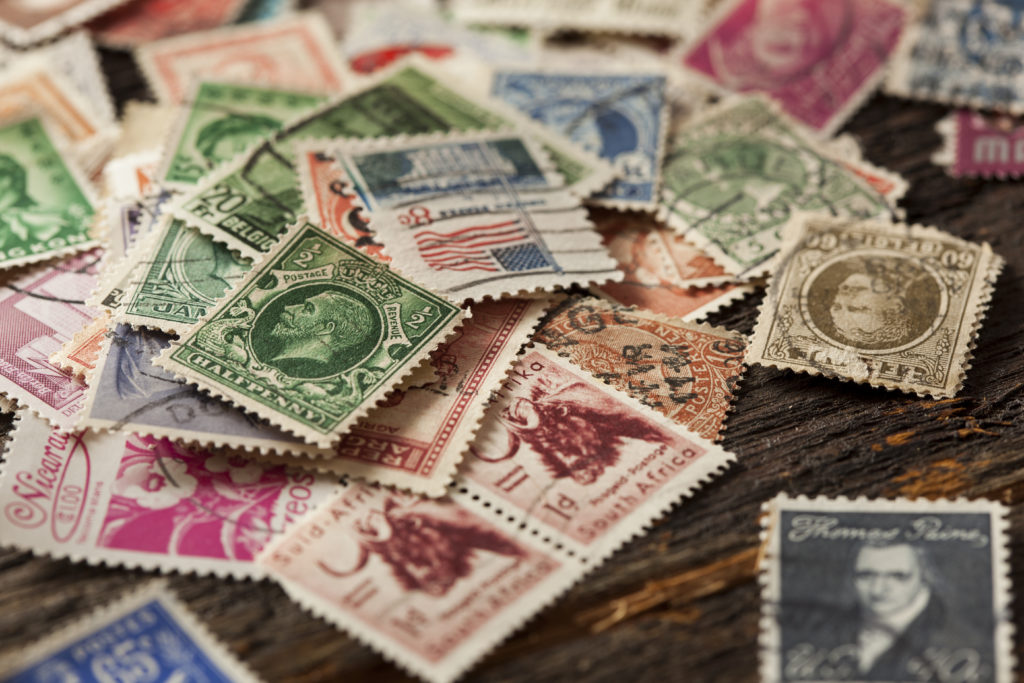 Pile of used vintage stamps on a wooden table