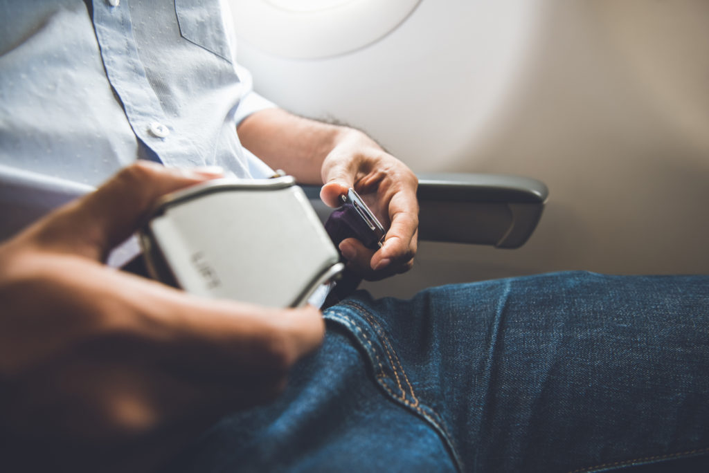 Close up of person buckling their seatbelt on airplane