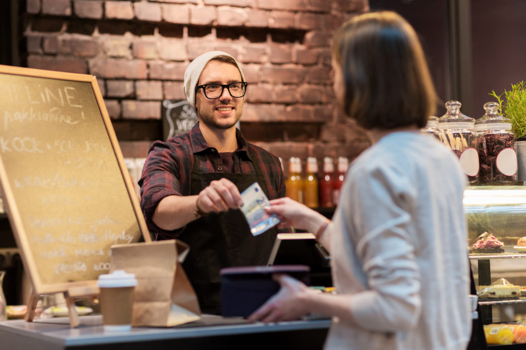 Woman paying for coffee in euros