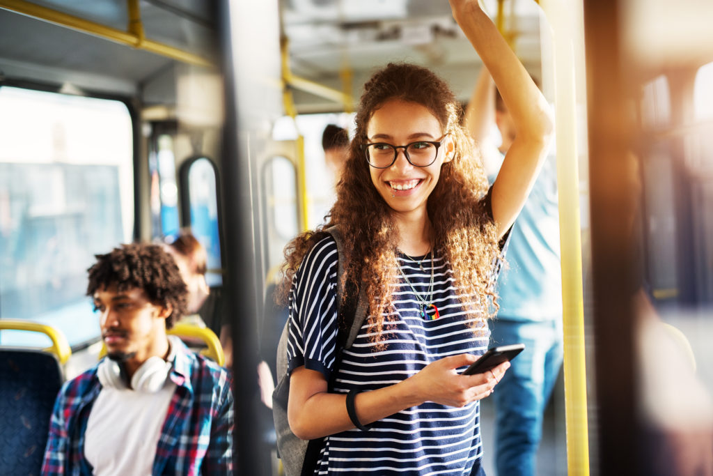 Woman standing holding the hand rails on a public bus