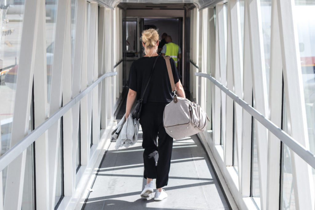 Woman walks down tunnel to board airplane