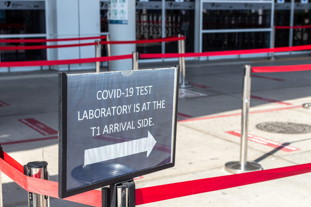 Sign post pointing to the line for the on-site airport COVID testing