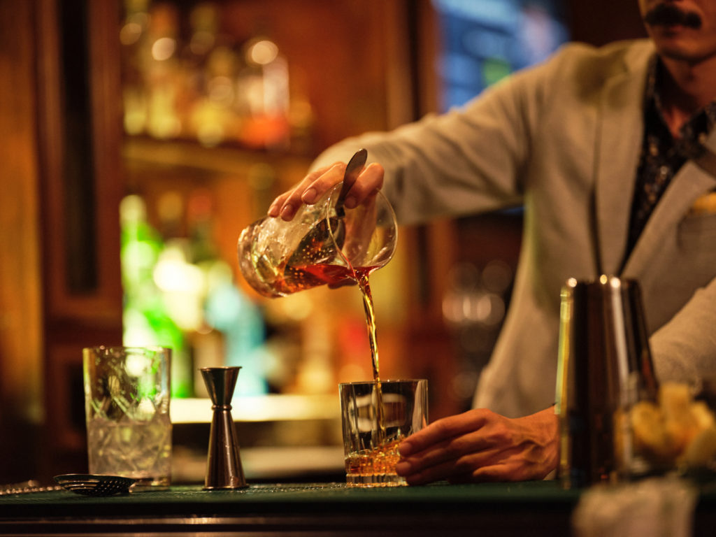 Close up of bartender pouring a drink at a bar at the Fairmont Grand Del Mar