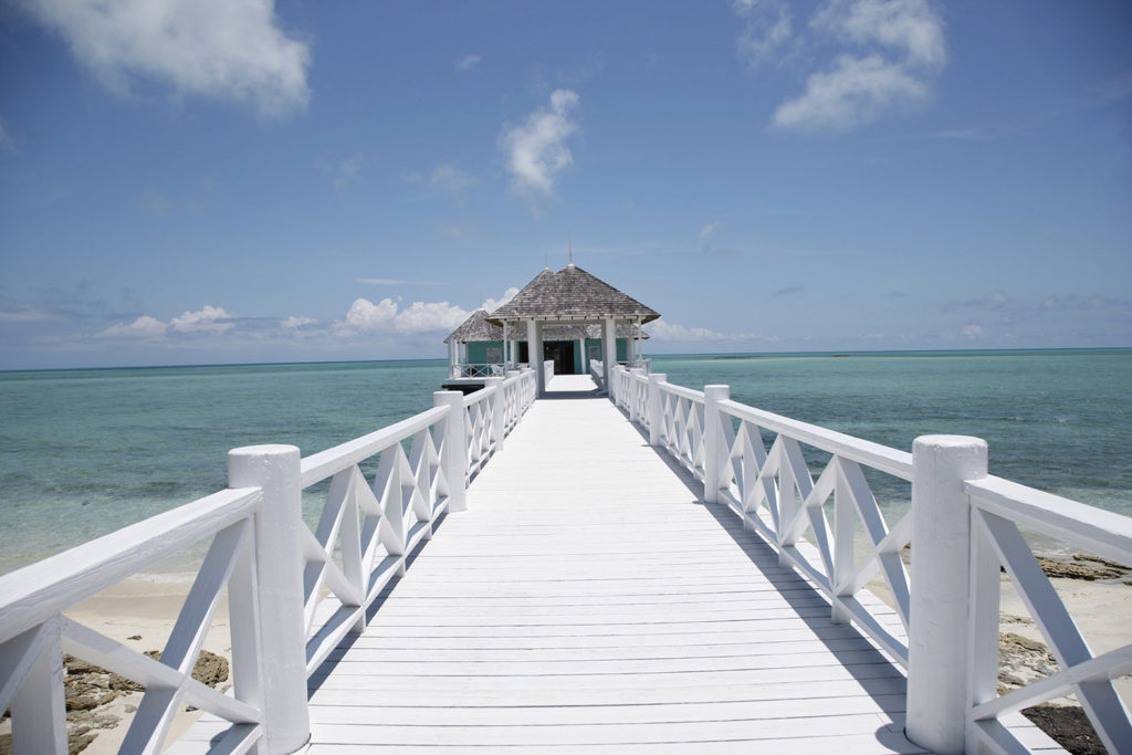 Wood plank pathway leading to the overwater spa at Kamalame Cay 