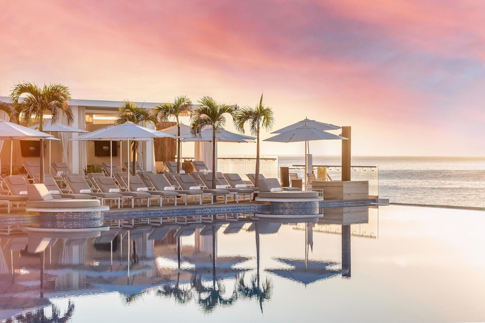 Outdoor lounge area by the pool at sunset at Le Blanc Spa Resort Adults-Only All-Inclusive, San Jose del Cabo, Mexico