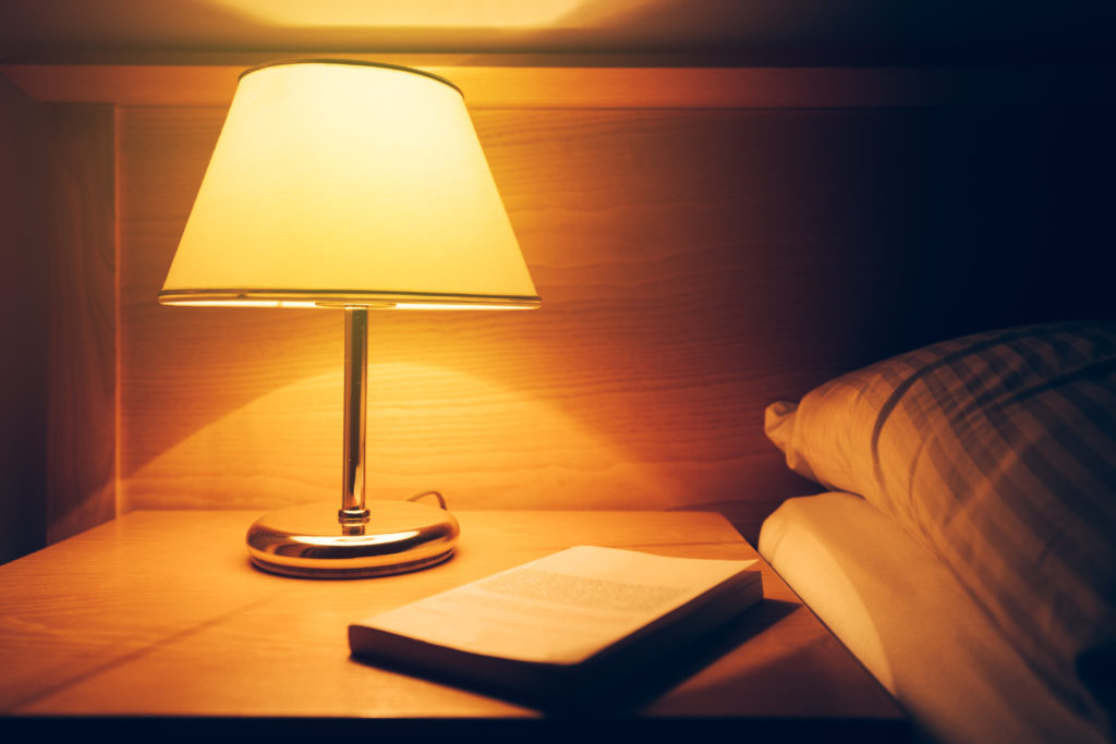 Retro style lamp on a nightstand with a book on top