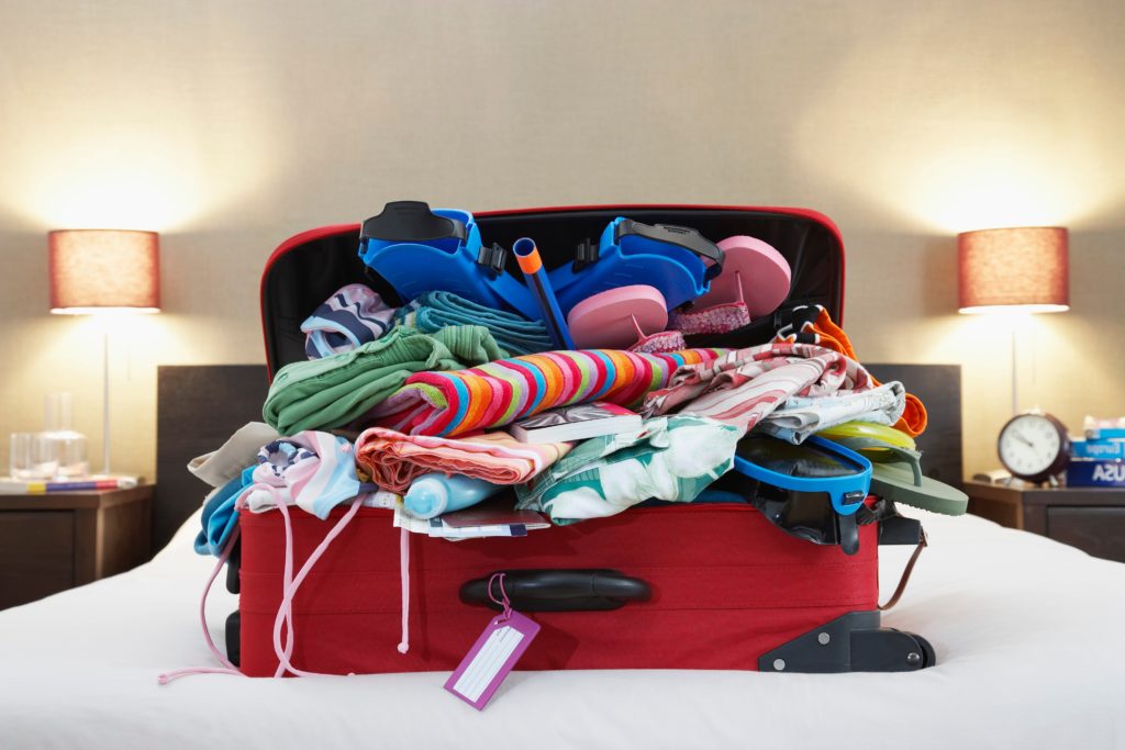 Overflowing suitcase on a bed