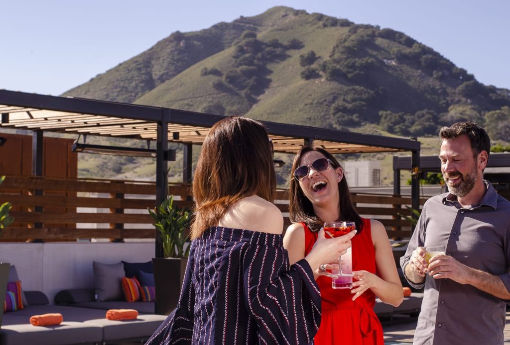 People enjoying drinks on Hotel Cerro's rooftop pool and bar in San Luis Obispo, California