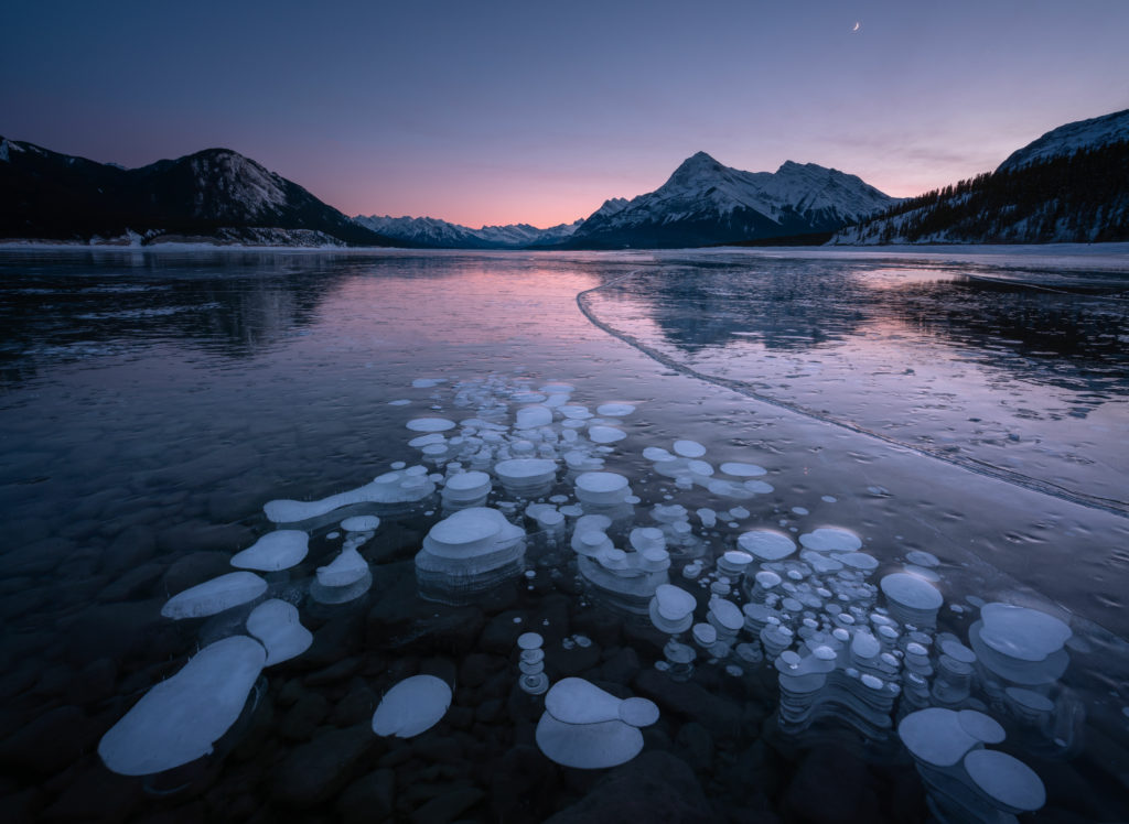 Air bubble and ice at sunrise on Abraham Lake in Canada