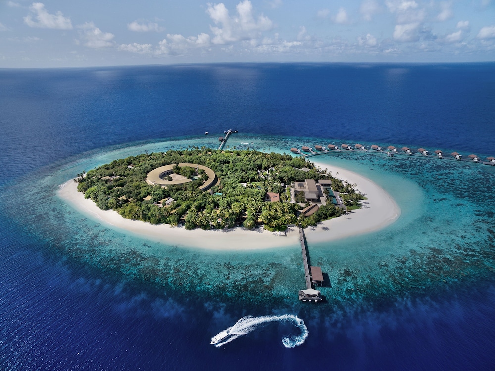 Aerial view of island and overwater bungalows at Park Hyatt Maldives