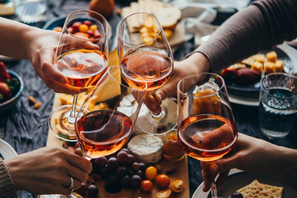 Bird's eye view of multiple people clinking glasses of red wine