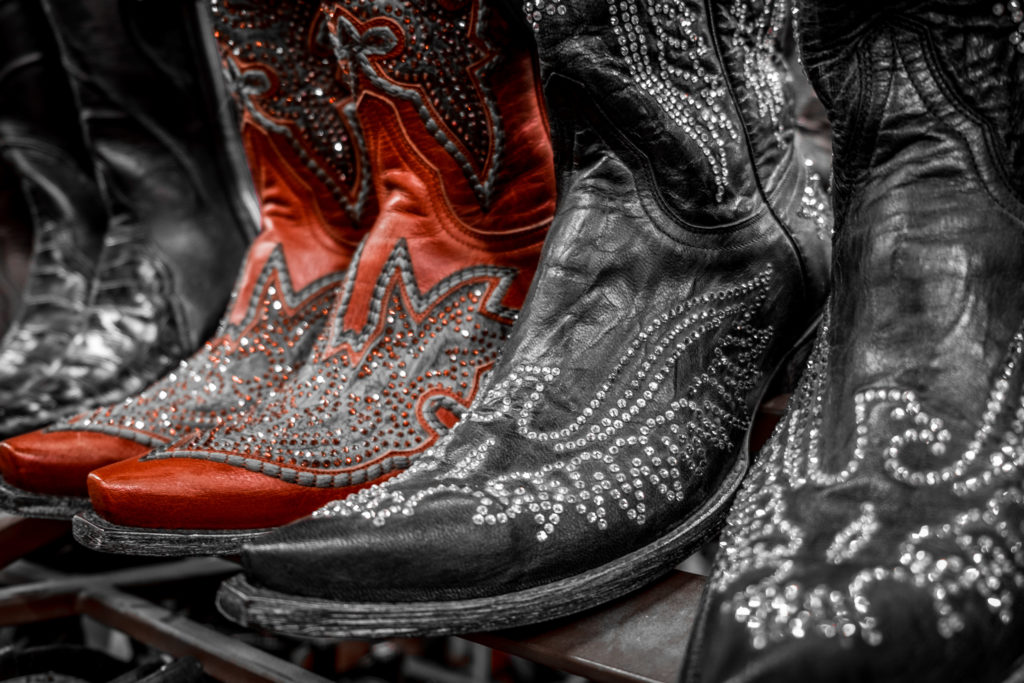 Close up of three pairs of rhinestone cowboy boots in a row