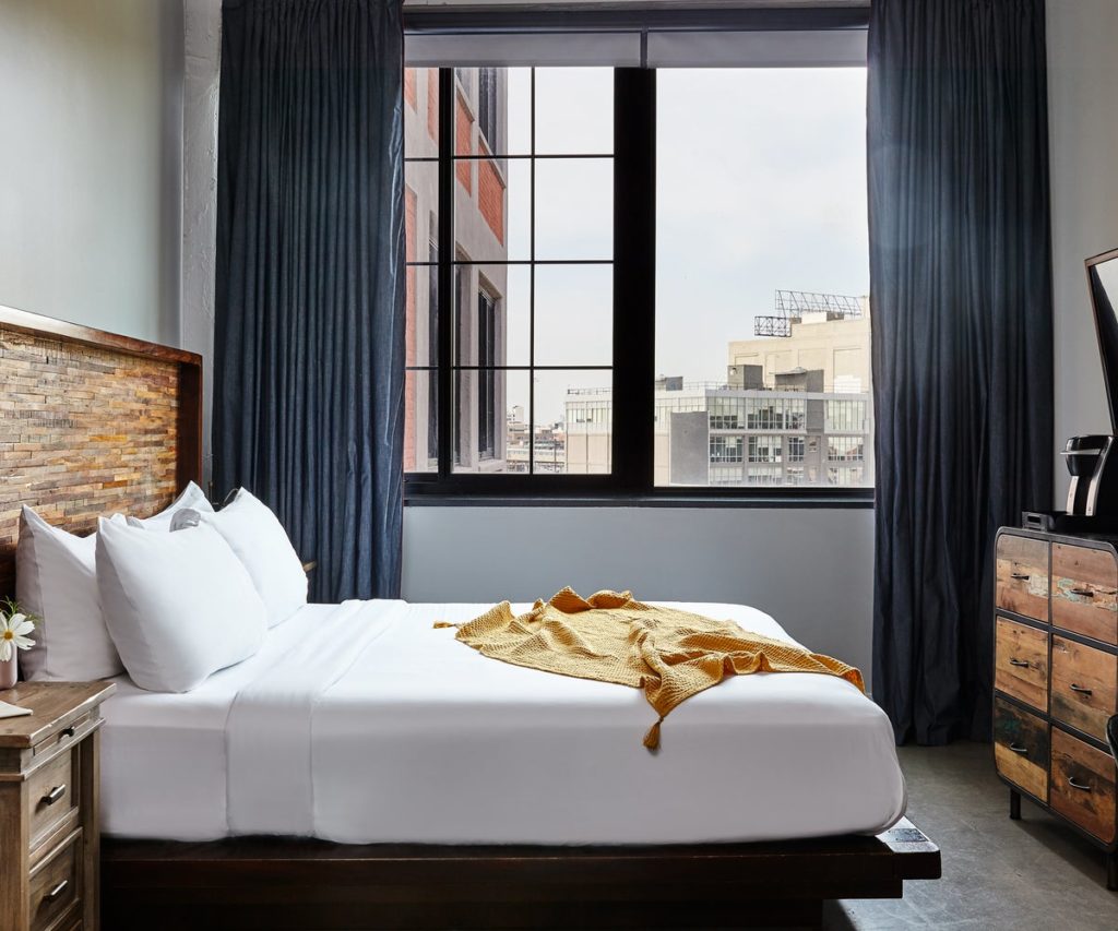 Bedroom with an open window at The Collective Paper Factory hotel in New York City