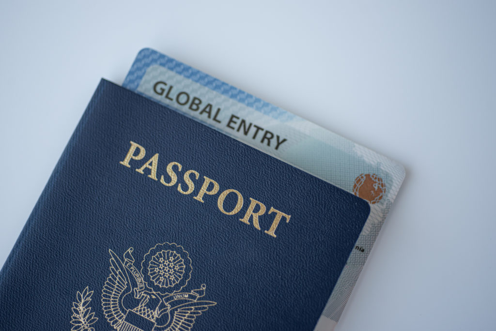 Passport with Global Entry paperwork inside on a white table