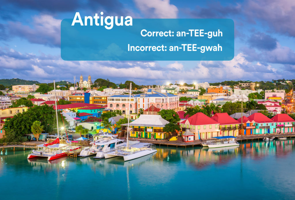 Colorful houses and boats on the coast in Antigua and Barbuda with graphic overlay showing the correct and incorrect way to pronounce "Antigua"