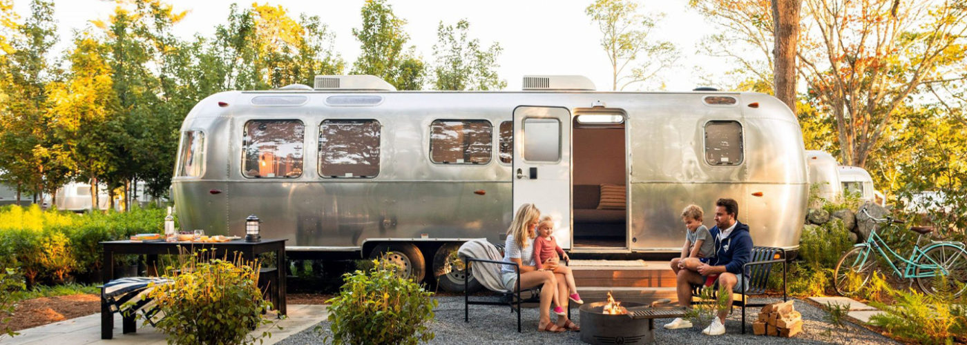 Family sitting outside in front of an airstream at Autocamp Cape Code