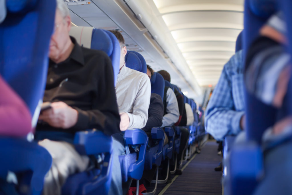 Aisle between rows of full airplane seats