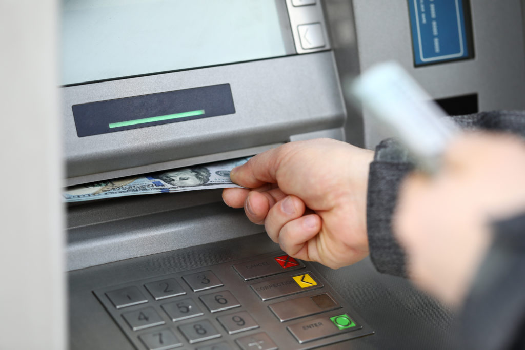 Close up of hands retrieving cash from the vending machine