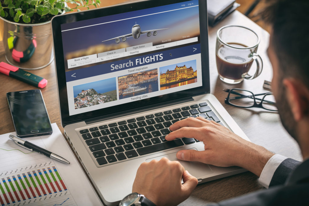 Close up of person searching for flights on laptop