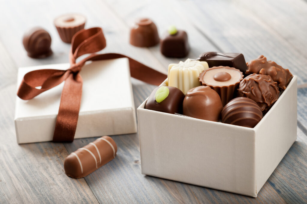 Box of fancy chocolates open on a grey table