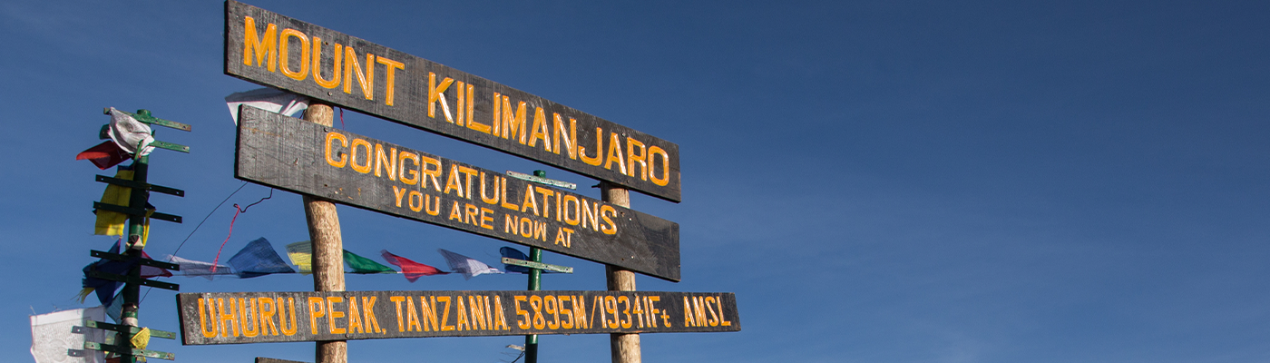 Sign at summit of Mount Kilimanjaro congratulating hikers for reaching the top