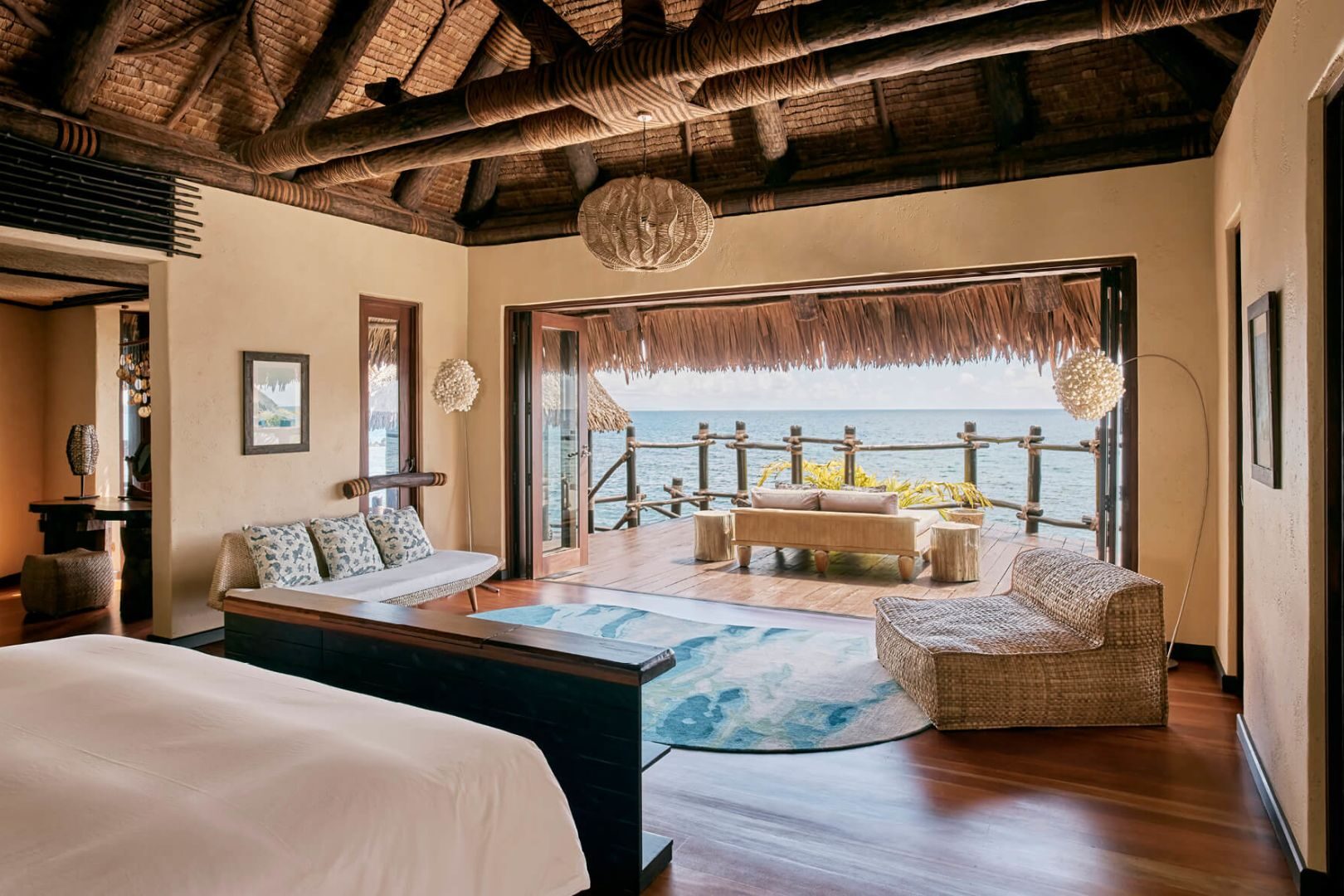 Main living space opening up onto a terrace in an overwater bungalow at COMO Laucala 