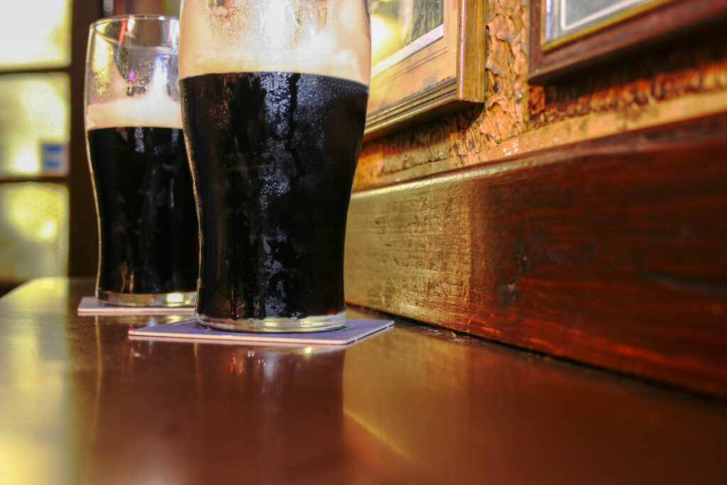 Two glasses of Irish stout beer on a wooden bar