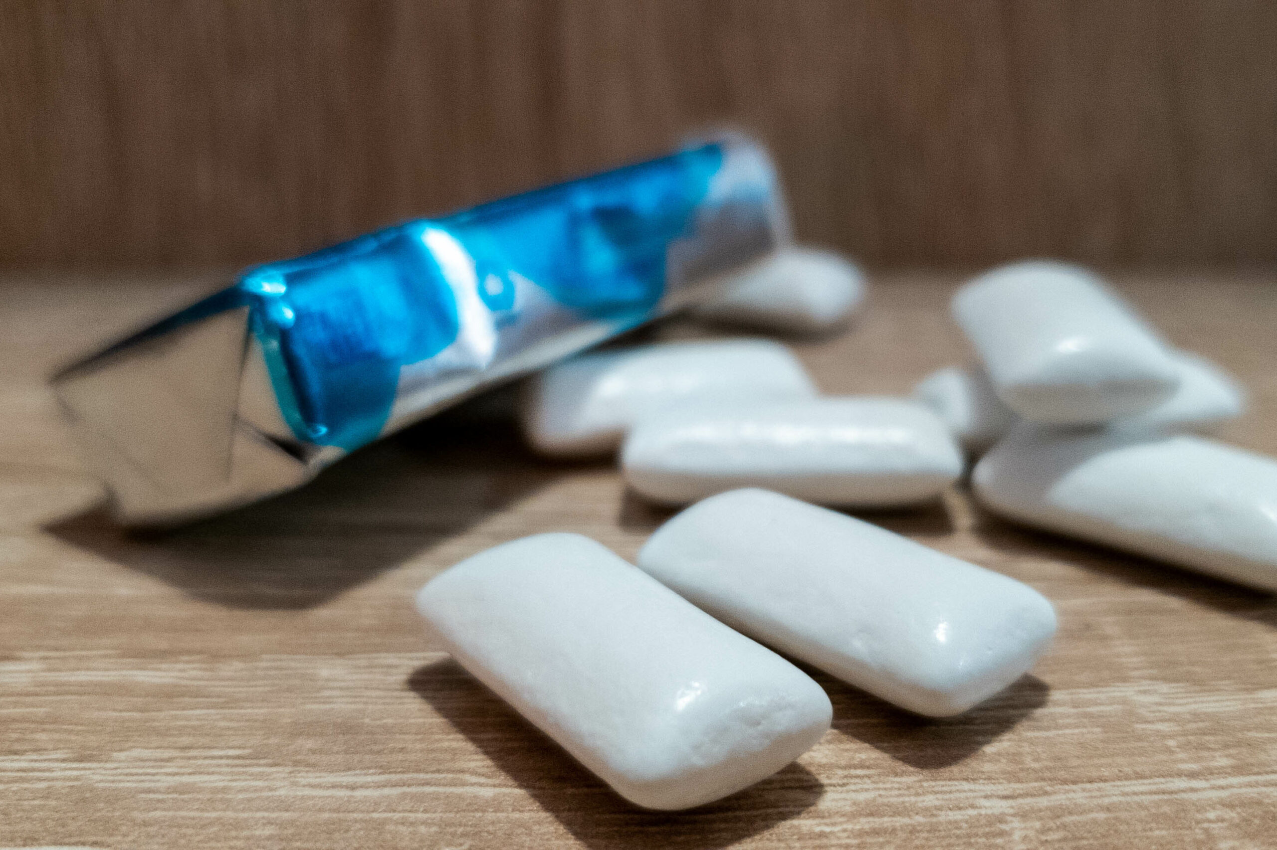 Close up of package of gum with a few loose pieces surrounding it