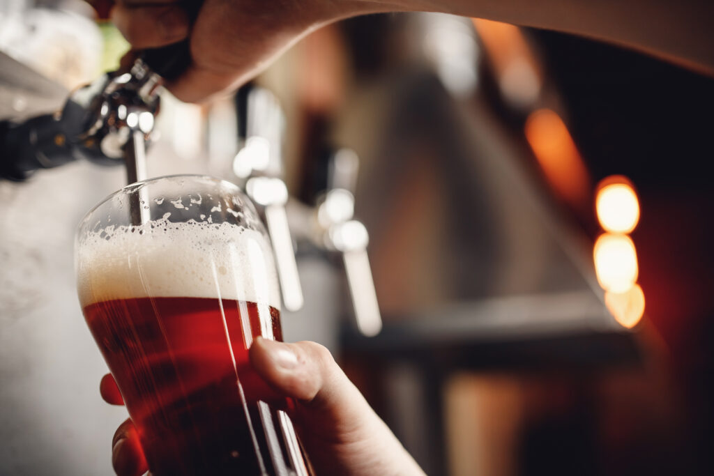 Close up of person pouring a beer from the tap