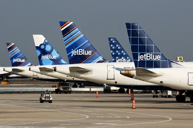 Several Jetblue branded airplanes on the tarmac