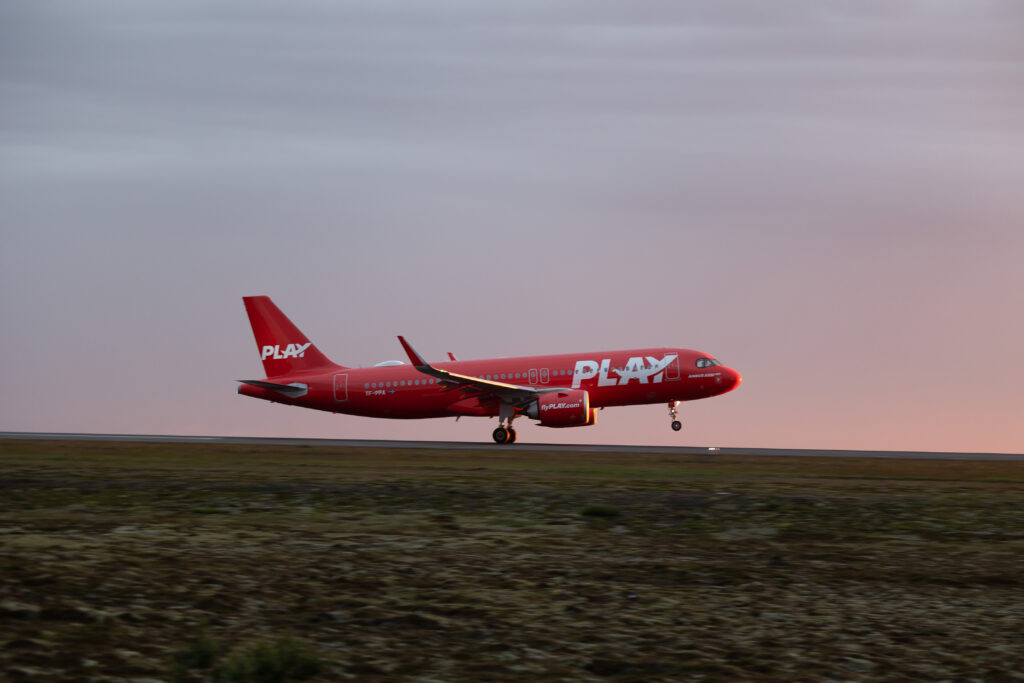 PLAY airplane taking off at dusk