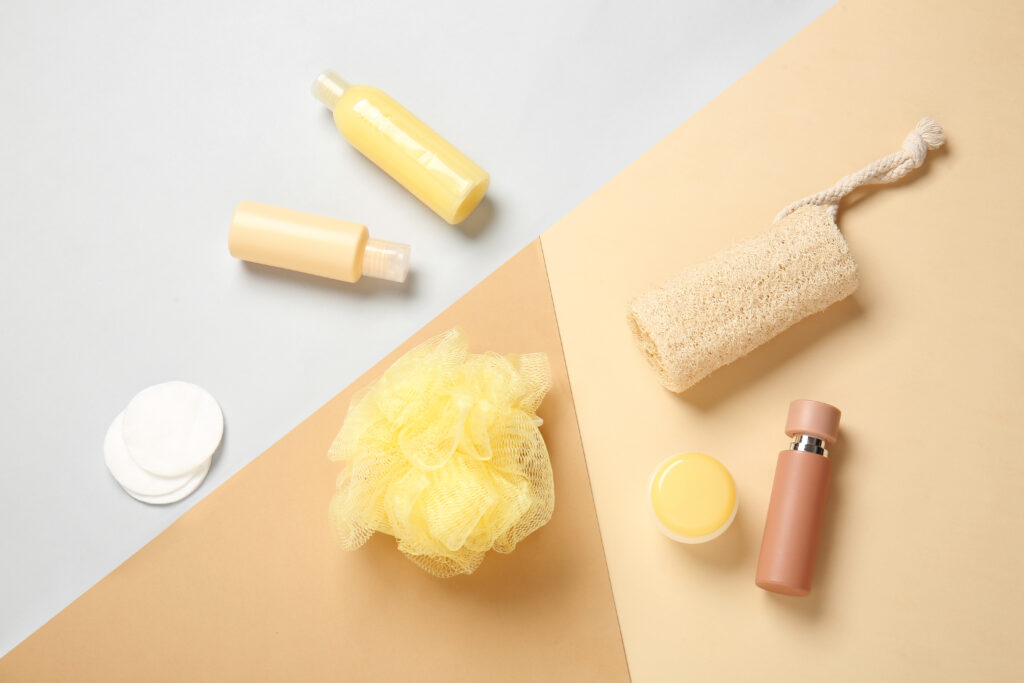 Shower materials laid flat on a dark yellow, grey, and light yellow backdrop